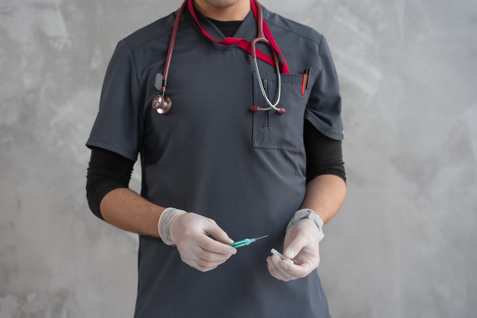 Healthcare worker with stethoscope holding a syringe ready for injection.