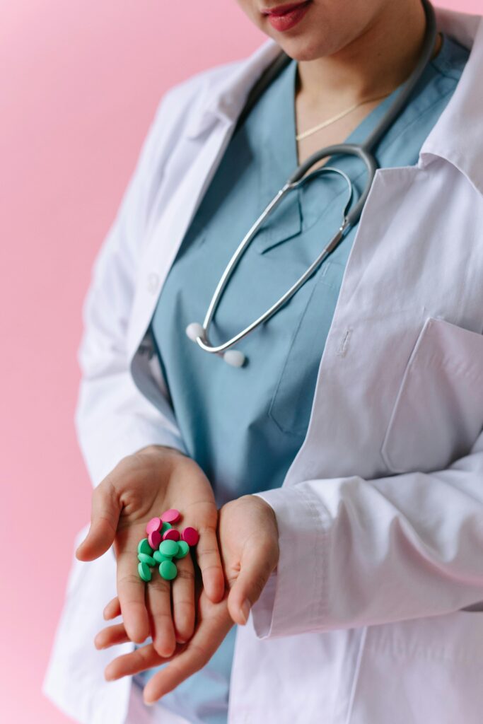 A healthcare professional holding colorful pills, symbolizing medical care and treatment.